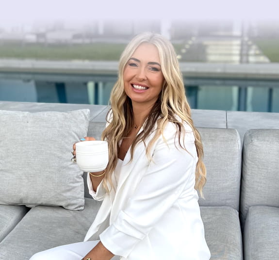 Danette May holding a cup.