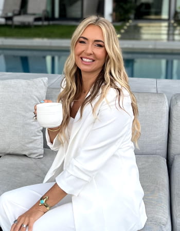 Danette May holding a cup.