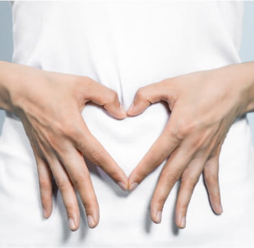 Woman creating a heart shape with her hands.